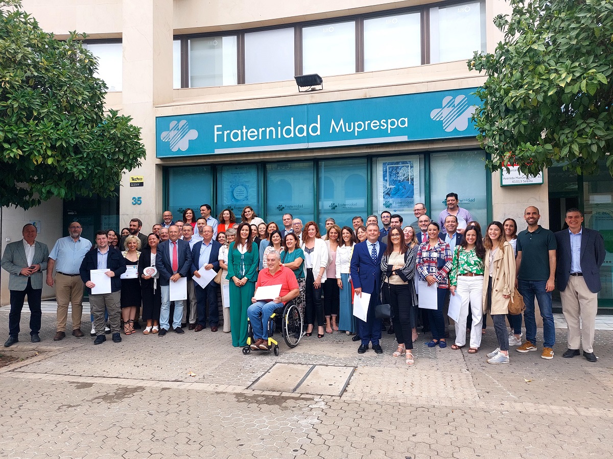 Foto_de_grupo_de_los_asistentes_al_acto_en_la_fachada_de_Fraternidad-Muprespa_en_Sevilla